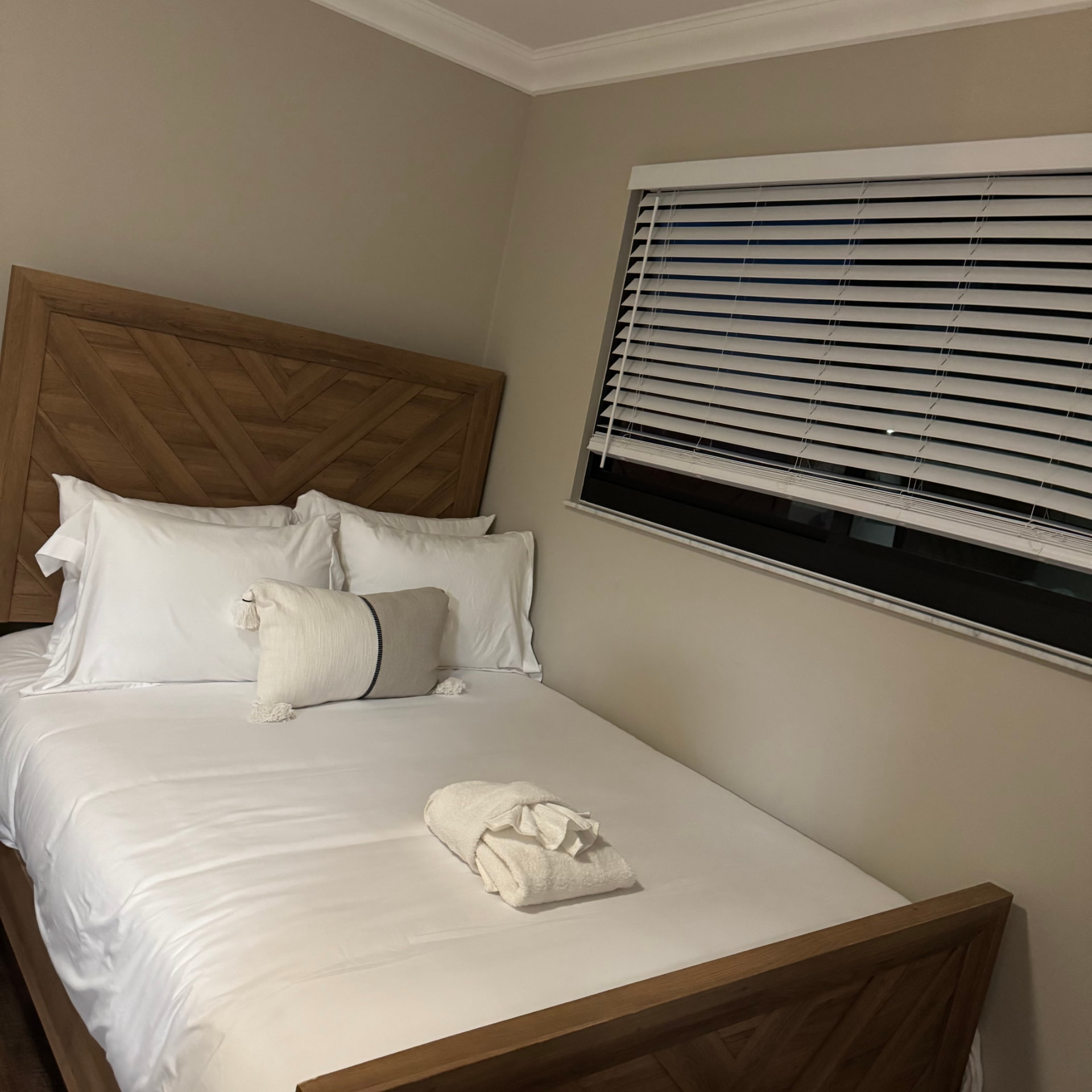 Guest bedroom with crisp white linens and folded towels
