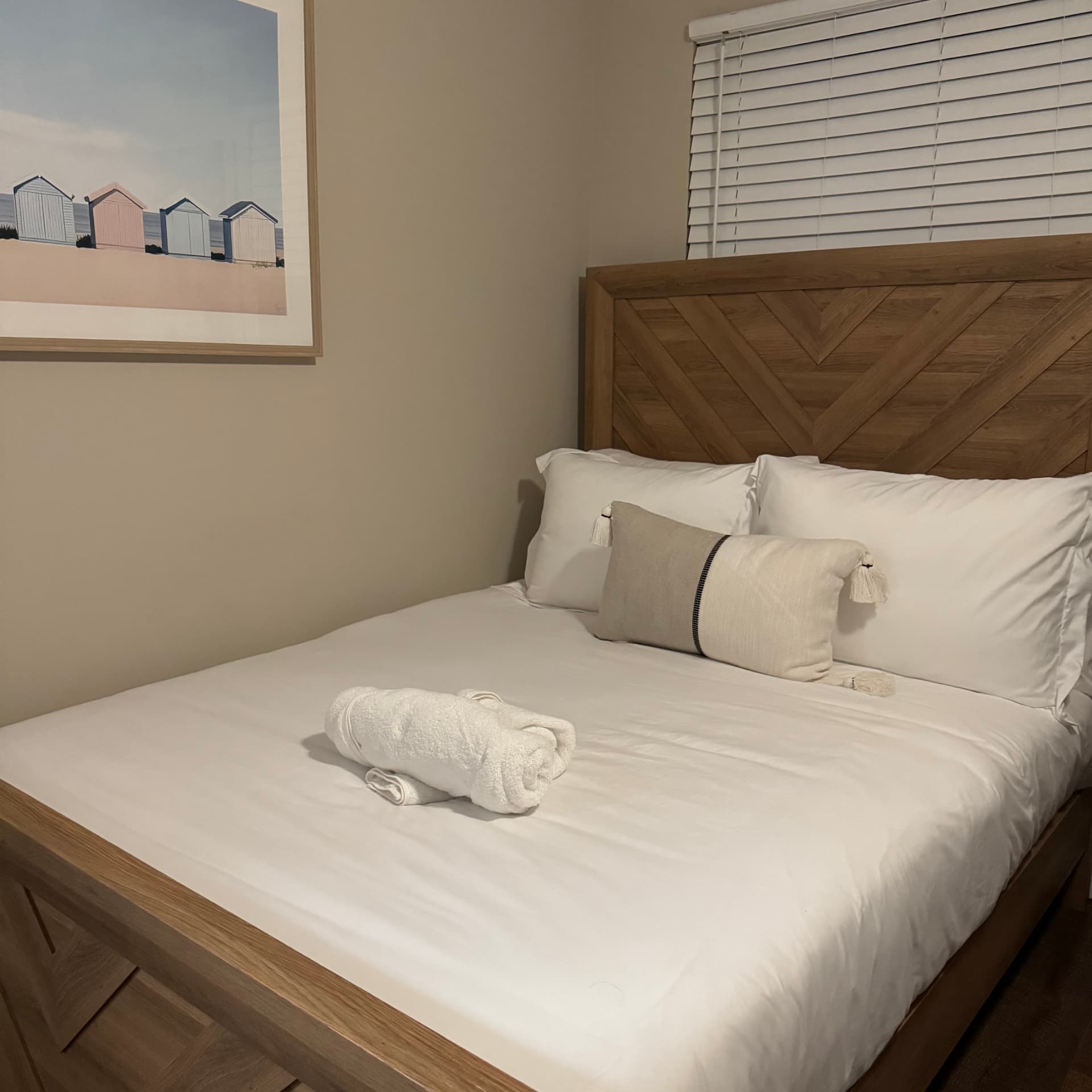 Turnover-ready bedroom with fresh bedding and towel presentation